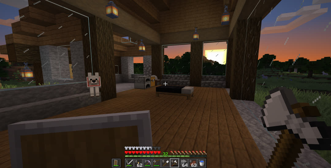 Interior view from the back right corner at sunset. The room is almost empty, only including a bed, furnace, chest, and crafting table. All of the windows now have glass panes.