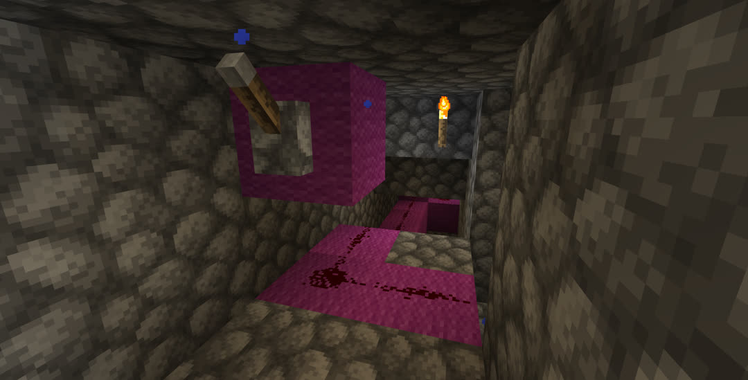 A narrow and branching cobblestone tunnel carrying a redstone circuit. The redstone components are placed on magenta wool. One block of wool with a lever attached portrudes from the ceiling, which is dripping water particles.