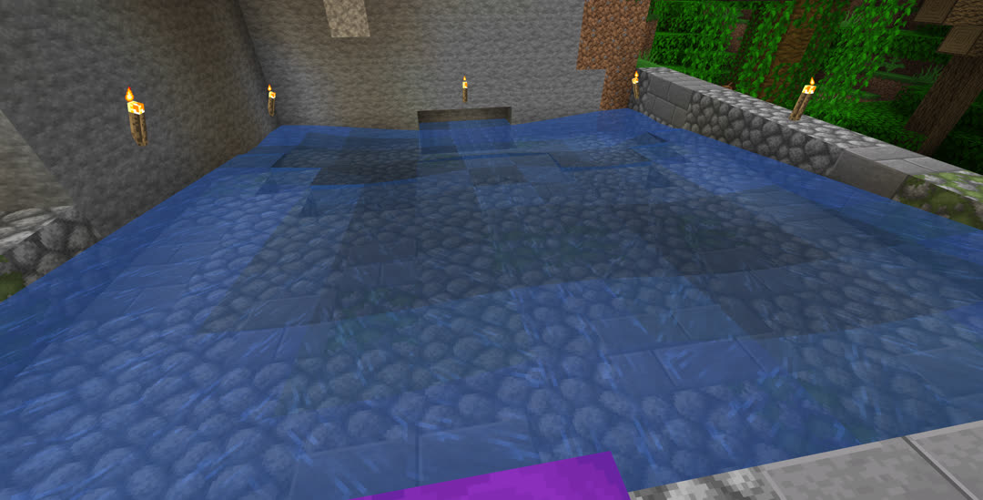 Plenty of space has been cleared, presumably around the spawner, at the bottom of which is a tray of flowing water. The exterior is a mix of cobblestone and stone bricks, both partially mossy.