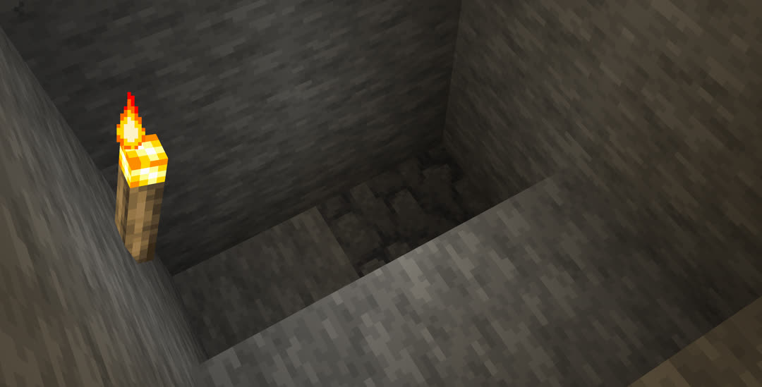 Bottom of the mine’s staircase with a single block of deepslate in the floor.