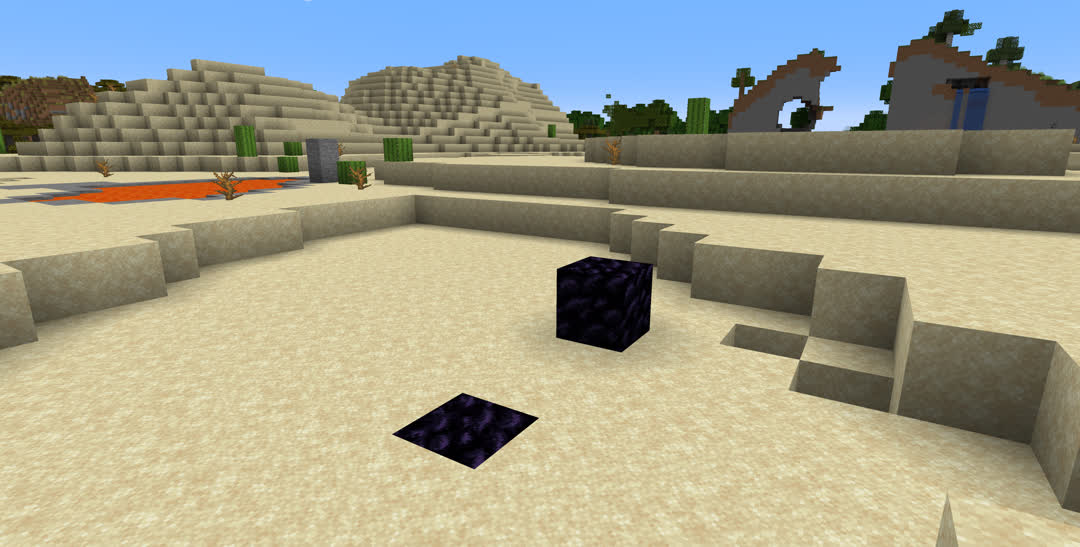 Desert scene with two blocks of obsidian in the foreground, one on top of the sand and the other buried in it.