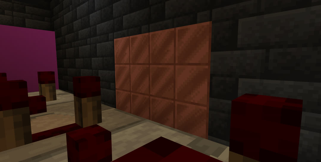 Looking through a redstone circuit at a backstage wall of the storage room, where the deepslate tiles are interrupted by a patch of cut copper blocks.