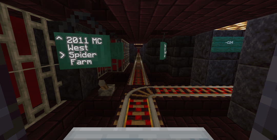 Rail junction at the former end‐of‐line. Three warped signs hang from the ceiling, each readable from one direction, with this one indicating “2011 MC West” continuing ahead and “Spider Farm” branching right.